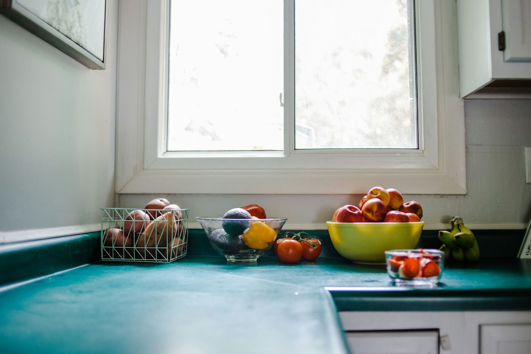 A clean kitchen counter showing a bowl of fresh vegetables next to a digital food scale.