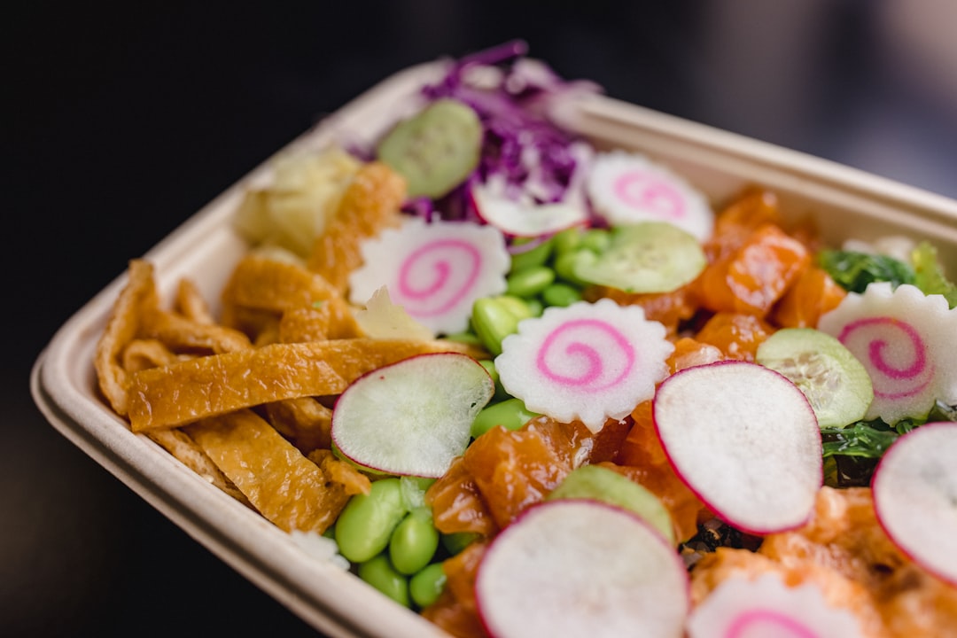 A healthy meal prep container placed next to an office keyboard, emphasizing healthy eating habits at work.